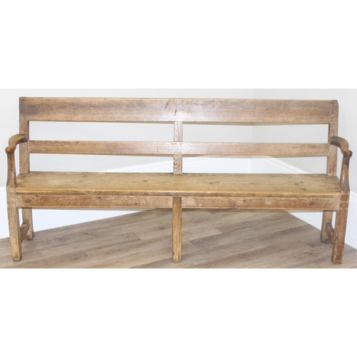 3 - An antique rustic pine bench with shaped arms and high back, likely 19th century, approx 205cm wide ... 