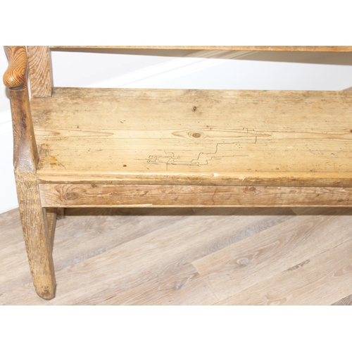 3 - An antique rustic pine bench with shaped arms and high back, likely 19th century, approx 205cm wide ... 