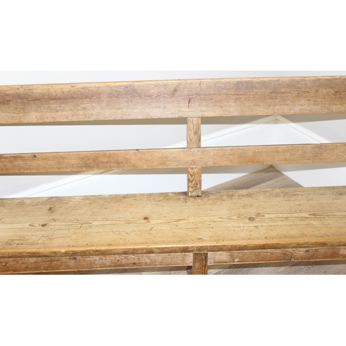 3 - An antique rustic pine bench with shaped arms and high back, likely 19th century, approx 205cm wide ... 