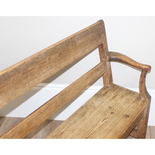 3 - An antique rustic pine bench with shaped arms and high back, likely 19th century, approx 205cm wide ... 