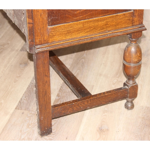 32 - An early 20th century oak sideboard with 2 drawers over a deep central drawer flanked by 2 doors, wi... 