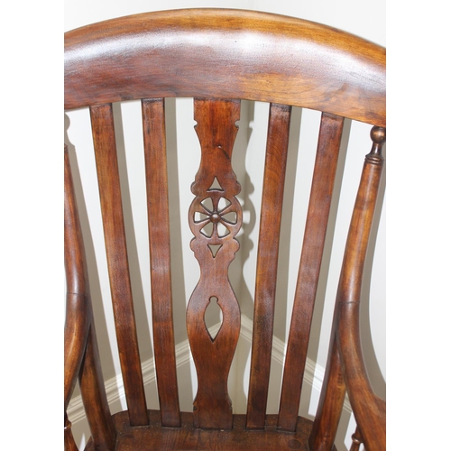 43 - An antique Windsor farmhouse armchair with decorative wheel back slat, approx 120cm tall