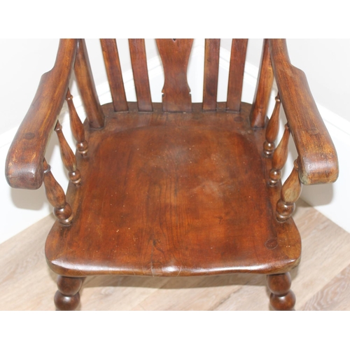 43 - An antique Windsor farmhouse armchair with decorative wheel back slat, approx 120cm tall