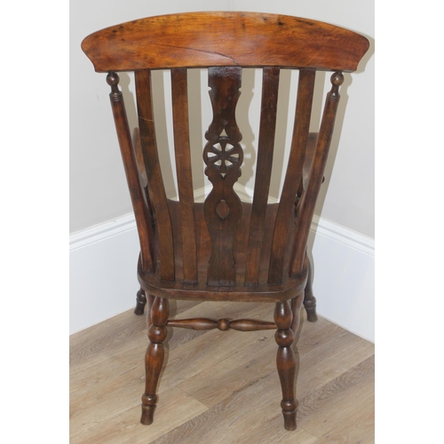 43 - An antique Windsor farmhouse armchair with decorative wheel back slat, approx 120cm tall