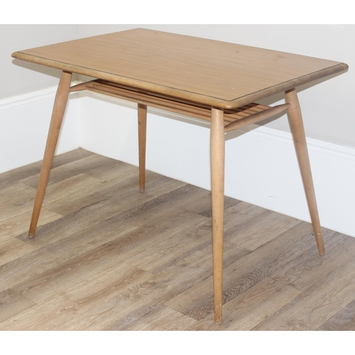 51 - A retro Ercol dining table, blonde finish with paper rack under, later stuck on Formica top, approx ... 