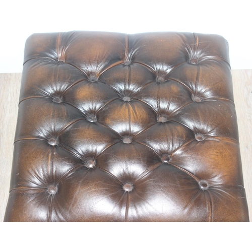 53 - A vintage brown faux leather Chesterfield style button footstool and shaped wooden legs, approx 56cm... 