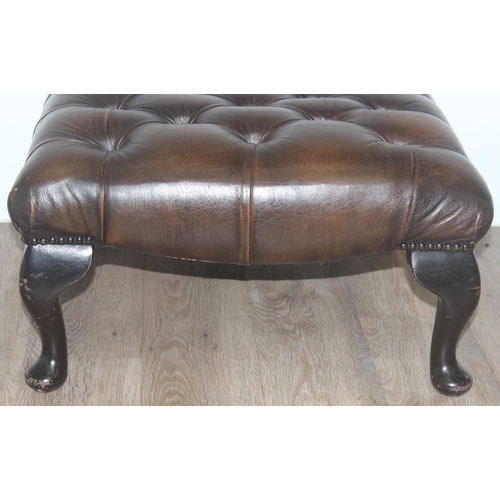 53 - A vintage brown faux leather Chesterfield style button footstool and shaped wooden legs, approx 56cm... 