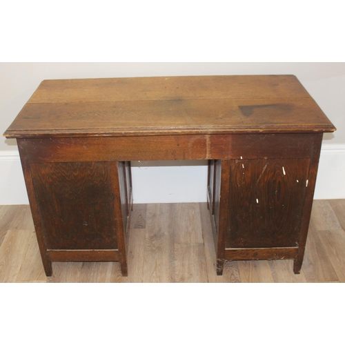 57 - An early 20th century oak desk with 9 drawers with brass cup handles, approx 130cm wide x 63cm deep ... 