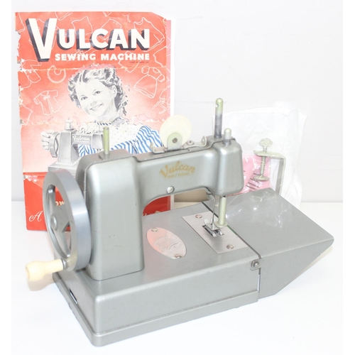 602 - A vintage miniature Vulcan sewing machine with instructions and accessories etc