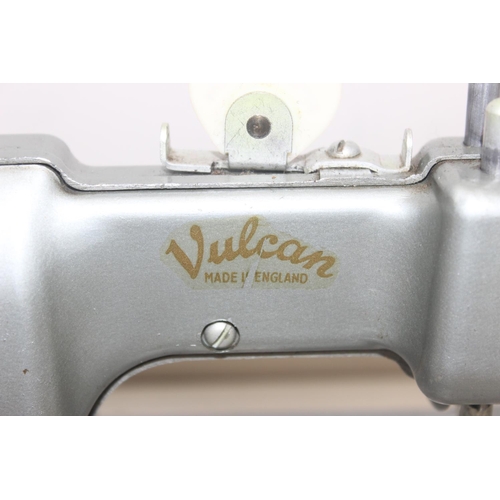 602 - A vintage miniature Vulcan sewing machine with instructions and accessories etc