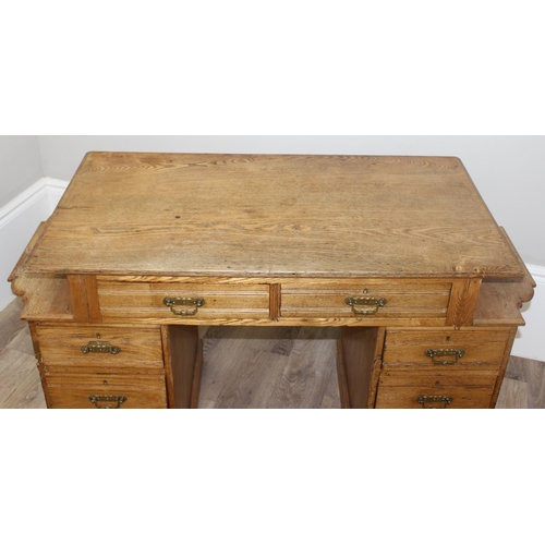 67 - An early 20th century light oak desk with 8 drawers and brass handles, unusual construction, approx ... 