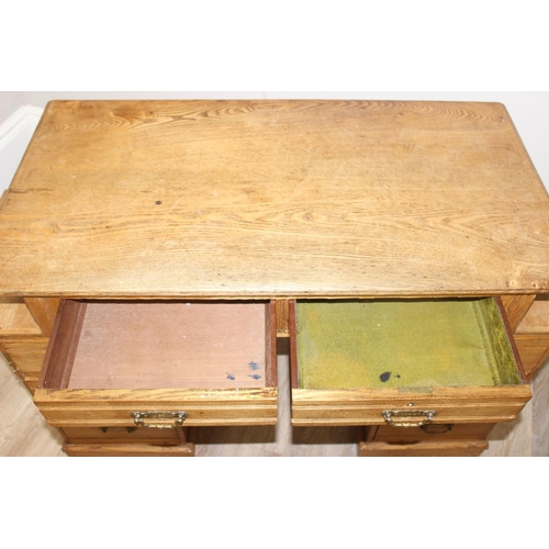 67 - An early 20th century light oak desk with 8 drawers and brass handles, unusual construction, approx ... 