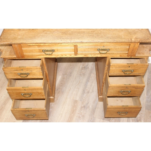 67 - An early 20th century light oak desk with 8 drawers and brass handles, unusual construction, approx ... 