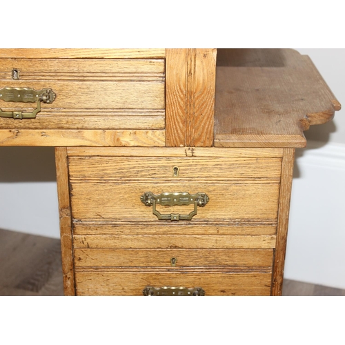 67 - An early 20th century light oak desk with 8 drawers and brass handles, unusual construction, approx ... 