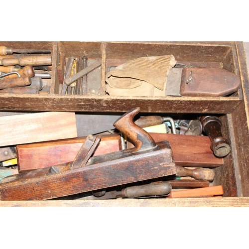 719 - A large vintage stained pine tool box with extensive contents to inc a number of wooden planes, saws... 