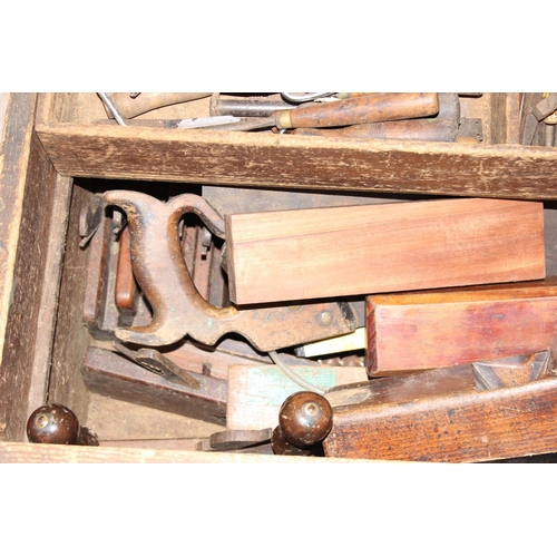 719 - A large vintage stained pine tool box with extensive contents to inc a number of wooden planes, saws... 