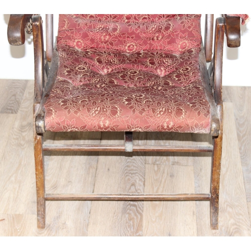 77 - An antique mahogany framed folding campaign chair with red patterned upholstery, likely c.1900, appr... 