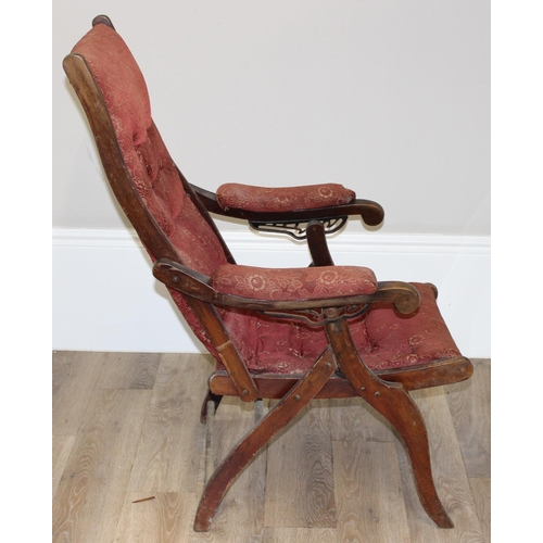 77 - An antique mahogany framed folding campaign chair with red patterned upholstery, likely c.1900, appr... 