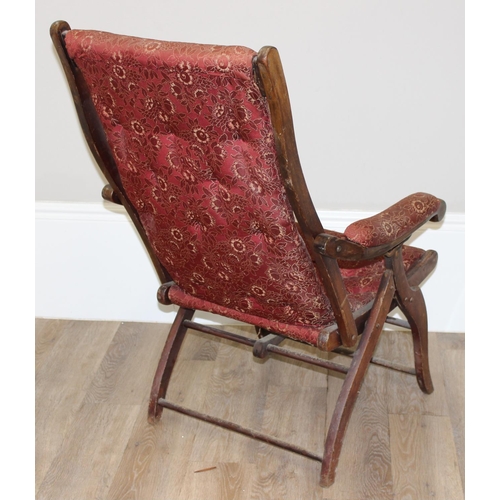 77 - An antique mahogany framed folding campaign chair with red patterned upholstery, likely c.1900, appr... 