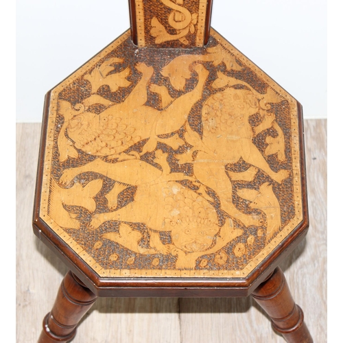 80 - An antique wooden spinning chair with pokerwork lion decoration, approx 87cm tall