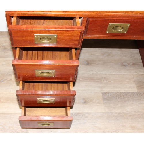 95 - A 20th century Oriental hardwood desk with brass campaign style handles and brown inset leather top,... 