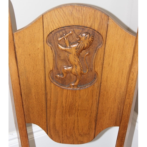 118 - A vintage light oak side chair with carved heraldic lion back, approx 100cm tall