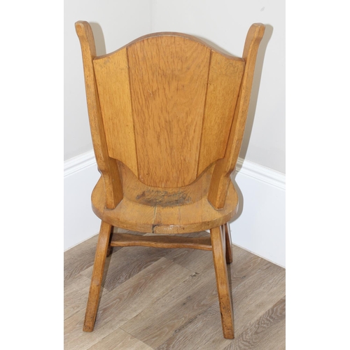 118 - A vintage light oak side chair with carved heraldic lion back, approx 100cm tall