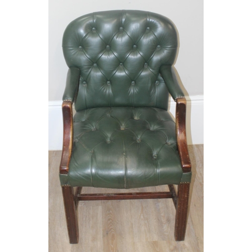 121 - A vintage button back Chesterfield style armchair with green faux leather upholstery and brass studs... 