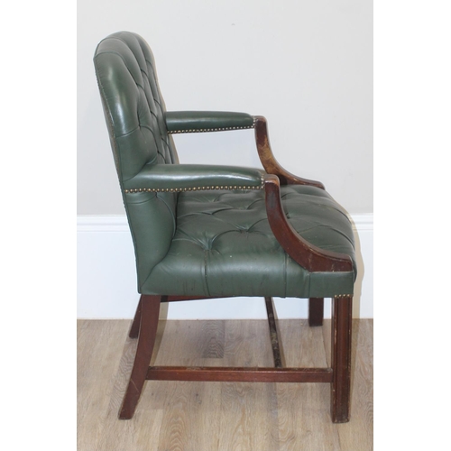 121 - A vintage button back Chesterfield style armchair with green faux leather upholstery and brass studs... 