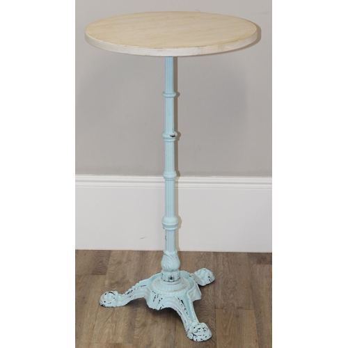 131 - A circular wooden topped Victorian style poseur bar or bistro table on ornate cast iron base, the ba... 