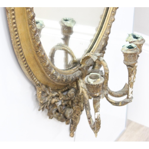 388 - A 19th century gilt framed oval girandole wall mirror, the mirror made from giltwood and gesso with ... 