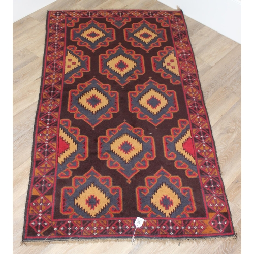 218 - A vintage Persian geometric designed rug with red ground and blue and cream gul design, approx 180cm... 