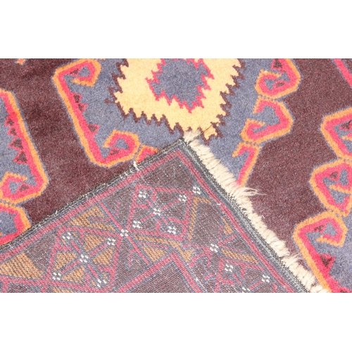 218 - A vintage Persian geometric designed rug with red ground and blue and cream gul design, approx 180cm... 