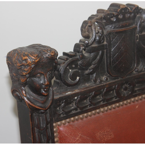 135 - A 17th century style carved oak chair with leather seat and back, the frame profusely carved with va... 