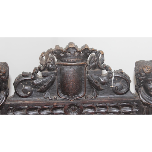 135 - A 17th century style carved oak chair with leather seat and back, the frame profusely carved with va... 