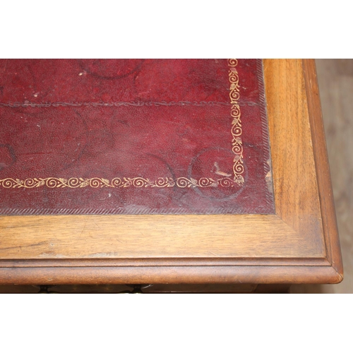 150 - An early 20th century Walnut desk by Hamptons of London, a walnut veneered 9 drawer desk with Georgi... 