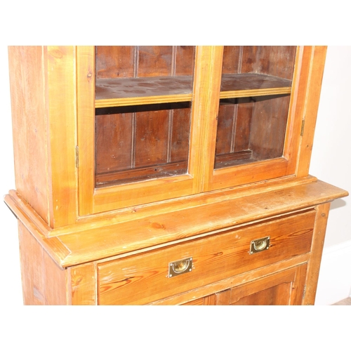 153 - An antique pitch pine dresser of slim proportions, the top with glazed doors, over a single drawer w... 