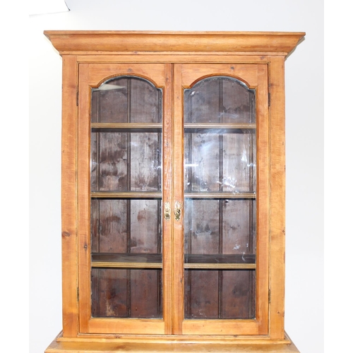 153 - An antique pitch pine dresser of slim proportions, the top with glazed doors, over a single drawer w... 