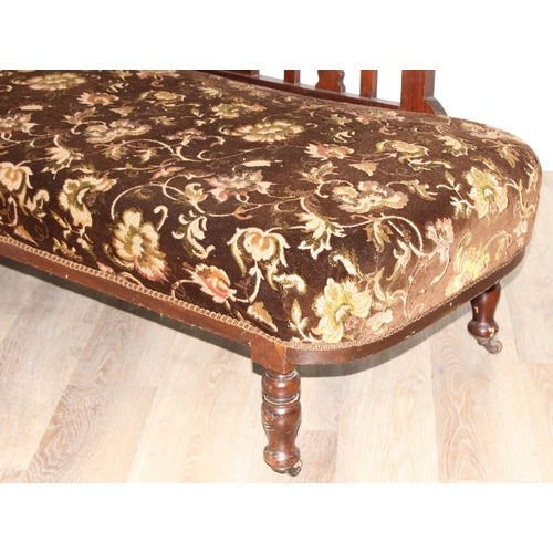 155 - An antique mahogany framed chaises longue with turned legs and carved details and floral patterned u... 