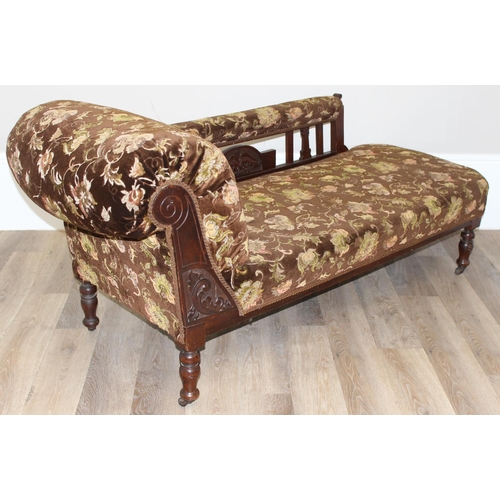 155 - An antique mahogany framed chaises longue with turned legs and carved details and floral patterned u... 