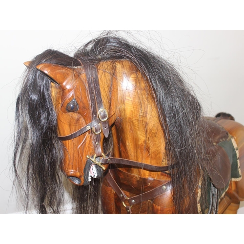 630 - A large vintage hand carved wooden rocking horse with leather saddle and horse hair mane and tail, s... 