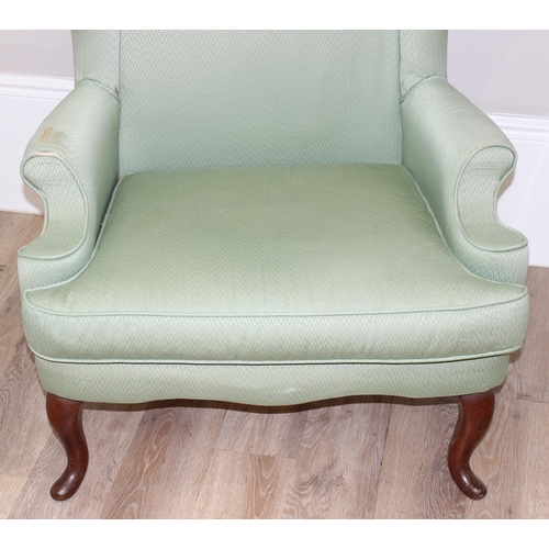 102 - 2 antique style wingback armchairs with wooden legs, one with celadon green coloured upholstery, the... 