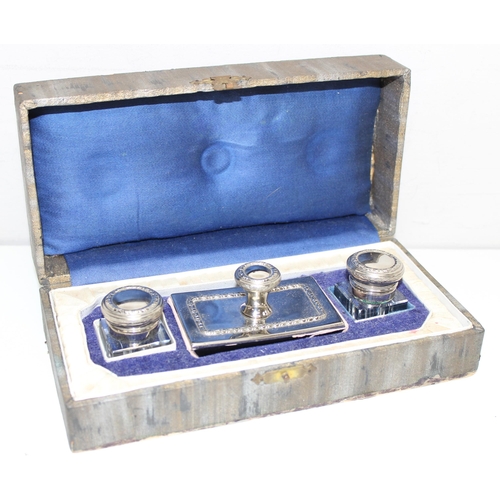 1039 - A vintage desk set comprising of a pair of glass inkwells and a desk blotter with silver plated moun... 