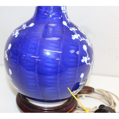 242 - A Chinese table lamp with shade, the body formed as a blue & white bottle vase decorated with prunus... 