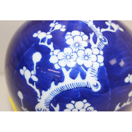 242 - A Chinese table lamp with shade, the body formed as a blue & white bottle vase decorated with prunus... 