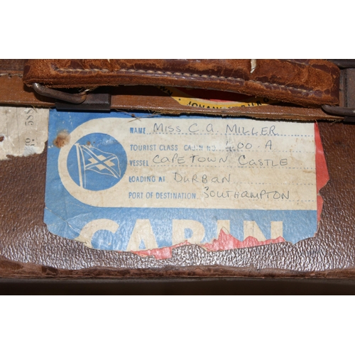 273 - 2 vintage suitcases with a large number of vintage luggage labels, the smaller case leather, the lar... 