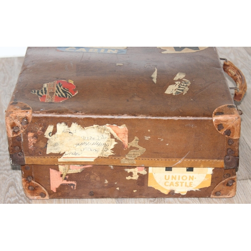 273 - 2 vintage suitcases with a large number of vintage luggage labels, the smaller case leather, the lar... 