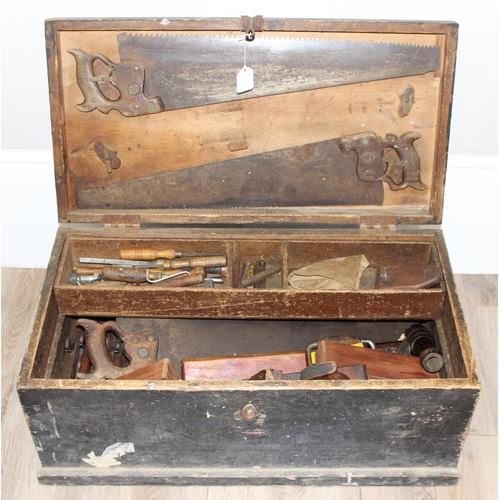 719 - A large vintage stained pine tool box with extensive contents to inc a number of wooden planes, saws... 