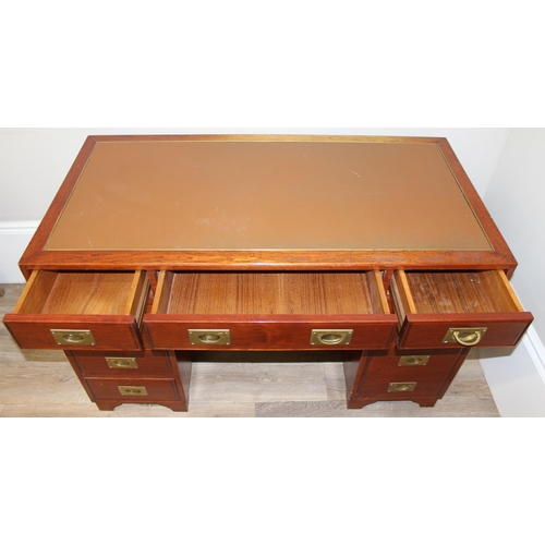 95 - A 20th century Oriental hardwood desk with brass campaign style handles and brown inset leather top,... 