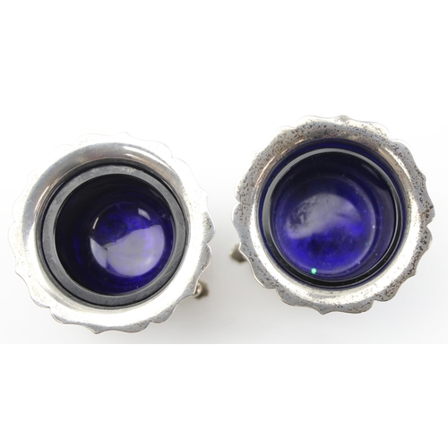 1054 - A pair of silver salts with blue glass liners, marked for Birmingham 1945 by Harrods, approx 74.74g ... 